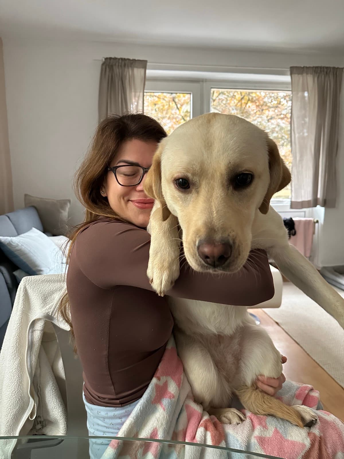 Mareike Stretz mit ihrem Labrador, in einem Wohnraum mit Herbstlicht.